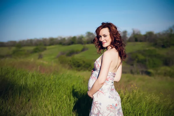 Jovem feliz mulher grávida relaxando e desfrutando da vida na natureza. — Fotografia de Stock