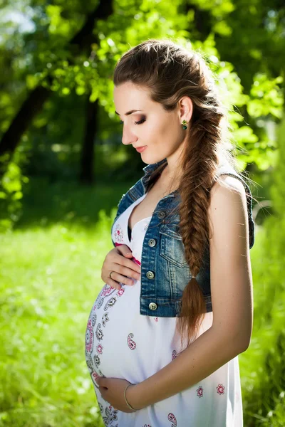 Joven mujer embarazada feliz con largo hermoso tress relajante un — Foto de Stock