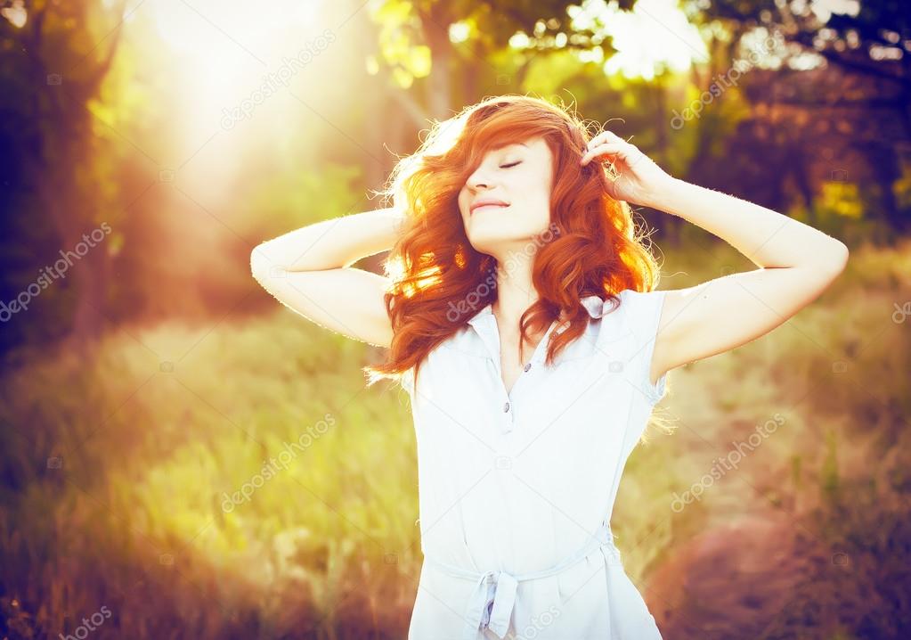 Emotional portrait of happy beautiful woman with red curly hair 