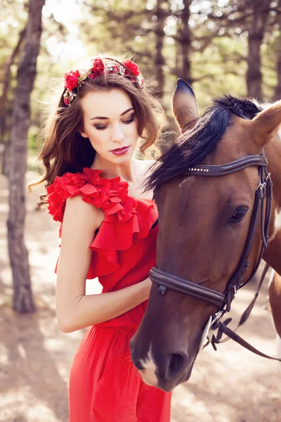 Bela jovem senhora vestindo vermelho vestido equitação um cavalo no ensolarado s — Fotografia de Stock