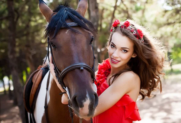 Hermosa joven vistiendo vestido rojo montando un caballo en soleado s —  Fotos de Stock