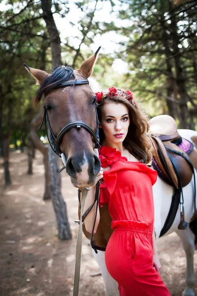 Красива молода леді в червоній сукні верхи на коні на сонячному — стокове фото