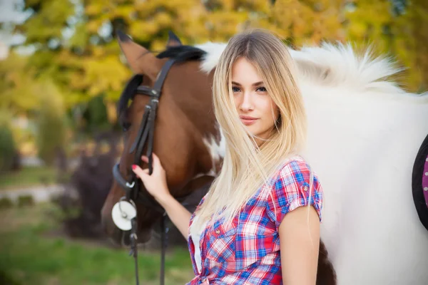 Bella signorina che indossa t-shirt e jeans cavalcando un cavallo a — Foto Stock