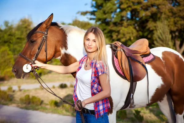 Bella giovane signora indossa vintage t-shirt e jeans a cavallo di un — Foto Stock
