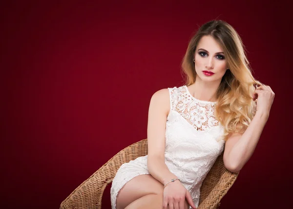 Blond seducive vacker kvinna i vit klänning sitter i armen — Stockfoto