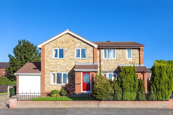 Elegante casa inglesa com porta vermelha e belo jardim frontal — Fotografia de Stock