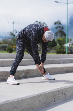 Genç adam parkta farklı ısınma ve kardiyo egzersizleri yapıyor..