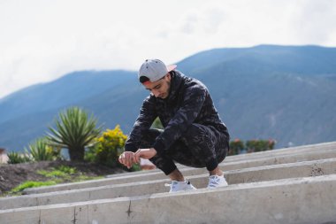 Genç adam parkta farklı ısınma ve kardiyo egzersizleri yapıyor..