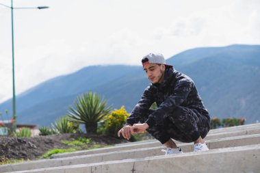 Genç adam parkta farklı ısınma ve kardiyo egzersizleri yapıyor..