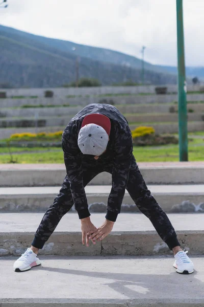 Genç adam parkta farklı ısınma ve kardiyo egzersizleri yapıyor..