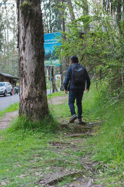 森の中を歩いている若い男 彼のバックパックと携帯電話の記録と写真を撮ると — ストック写真