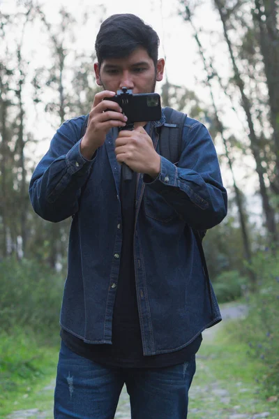 stock image Young man walking in the woods taking selfies. To show your friends.