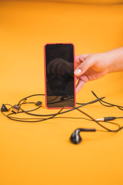 Elinde cep telefonu olan genç bir kadın..