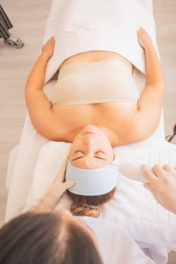 Genç Kadın Spa 'da bir günün tadını çıkarıyor. Cildinizin ve yüzünüzün bakımı için farklı tedaviler uyguluyorsunuz..