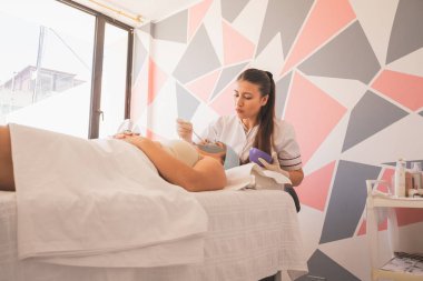 Genç Kadın Spa 'da bir günün tadını çıkarıyor. Cildinizin ve yüzünüzün bakımı için farklı tedaviler uyguluyorsunuz..
