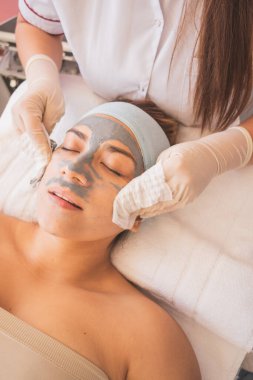 Genç Kadın Spa 'da bir günün tadını çıkarıyor. Cildinizin ve yüzünüzün bakımı için farklı tedaviler uyguluyorsunuz..