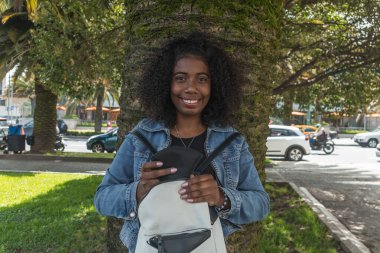 Yüzünü örtmek için maske takan Afro-Amerikalı genç bir kadın. Tüm biyo-güvence yöntemlerine uyuluyor.