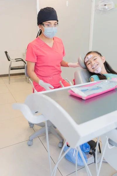 在牙科诊所接受牙科治疗的女孩照顾你的牙齿和牙具 — 图库照片