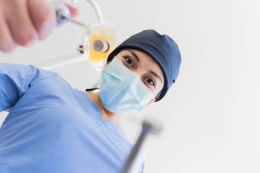 Ofisinde genç bayan profesyonel dişçi var. Tüm hastalarına profesyonel bir şekilde bakıyor..