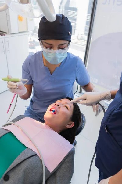 年轻的女牙医对病人进行了牙科治疗 以便她能尽快康复 — 图库照片