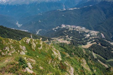 Dağlarda giden teleferiğin manzarası güzelmiş. Mesajın için yer aç. Geniş açıyla vurulmuş..