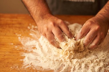 Pişirmek için taze hamur yapmak için unun içine bir aşçının parmaklarını sokuyorum.