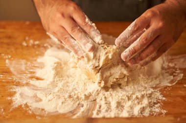 Unun içinde pişirmek için taze hamur elde etmek için bir aşçının elleri..