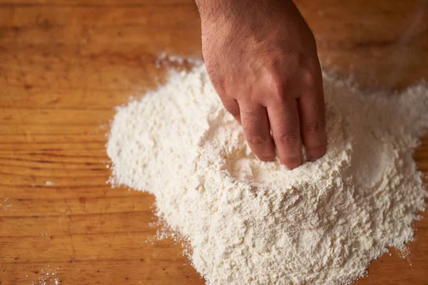 Mãos Cozinheiro Fazem Vulcão Farinha Uma Mesa Madeira — Fotografia de Stock