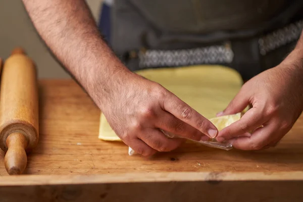 Tereyağı. Merdaneli adam yemek pişirmek için yağı düzleştirir..