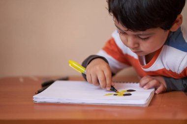 Anaokulu aktiviteleri. Çocuk çok konsantre bir şekilde çiziyor..