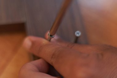 Bir adamın elleri tahtayı vidalıyor. Evde mobilya montajı. Marangozluk oturumu.