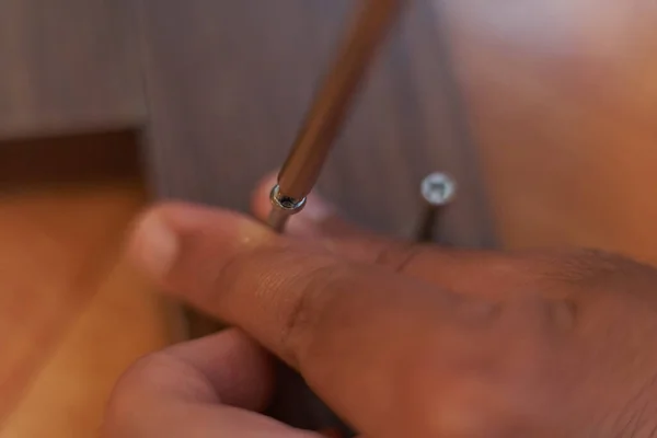 Bir adamın elleri tahtayı vidalıyor. Evde mobilya montajı. Marangozluk oturumu.