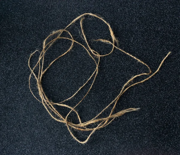 Tangled string on a black background,tangled canvas thread,