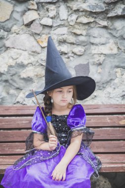 Büyüleyici genç büyücü, sihirli değneğiyle üzgün.