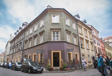 Varşova, Polonya, Ağustos 2017: Varşova 'da güzel bir köşe evi. Turistler kaldırımlı sokaklarda yürüyor