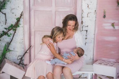 Mutlu anne, oturma odasında kızlarına sarılıyor.