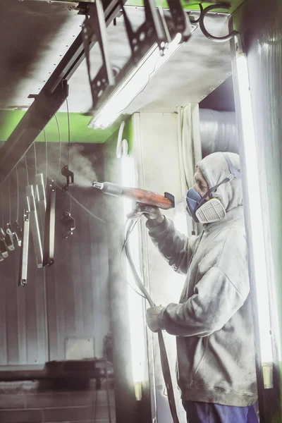 Bila Tserkva, Ukrayna, Mart 2021: İşçi bir fabrikada metal parçaları boyuyor