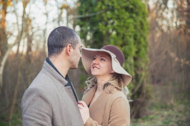 Güz parkında ceketli evli bir çift yürüyor.