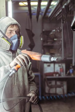 Bila Tserkva, Ukrayna, Mart 2021: İşçi bir fabrikada resim yapmadan önce parçaları asıyor