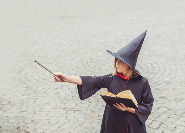 Kaledeki genç büyücü sihirli değnekle sihirbazlık yapıyor.