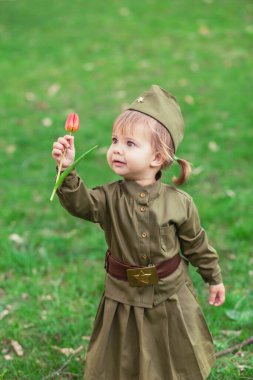 Sovyet askeri üniformalı, elinde lale olan sevimli bir kız.