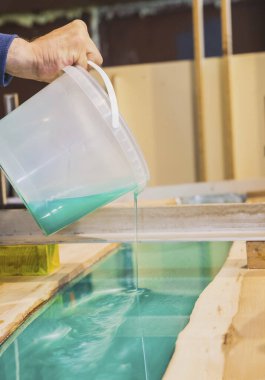 Marangoz atölyedeki mutfak masasına turkuaz epoksi döker.