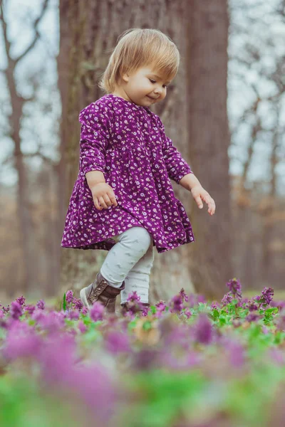 Ξανθό Μωρό Ένα Χρωματιστό Φόρεμα Τρέχει Ένα Ξέφωτο Δάσος Λουλούδια — Φωτογραφία Αρχείου