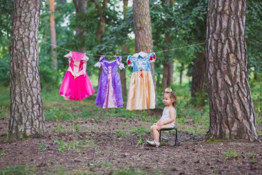 Çekici bebek kurulamak için prenses kostümleri asmış.