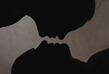 Öpüşen evli bir çiftin silüeti. Yin ve Yang..