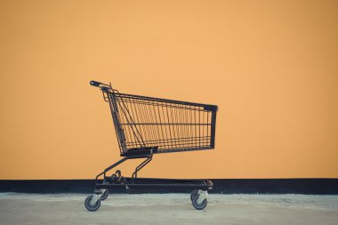 Minimalizm tarzı, alışveriş sepeti ve sarı duvar.