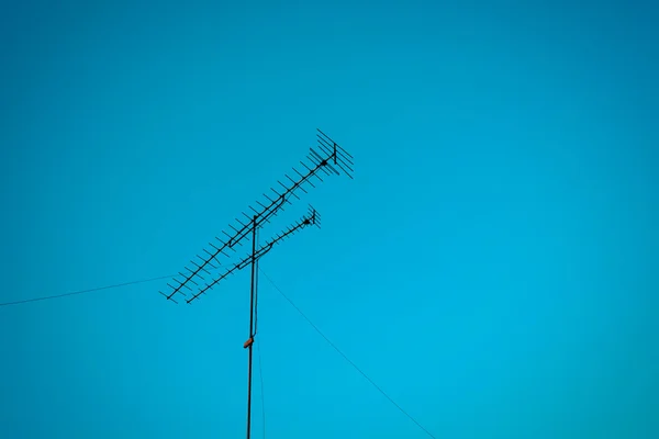 Antena de TV e céu azul, processo em estilo vintage — Fotografia de Stock