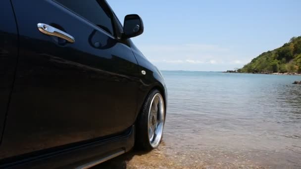 Bilparkering med krom hjul mot havet på beach — Stockvideo