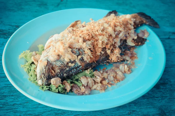 Peixe frito em prato na mesa de madeira azul — Fotografia de Stock