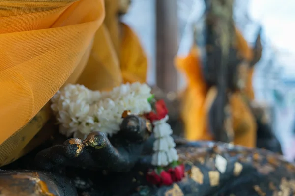 Guirnalda de flores en estatua de buda — Foto de Stock